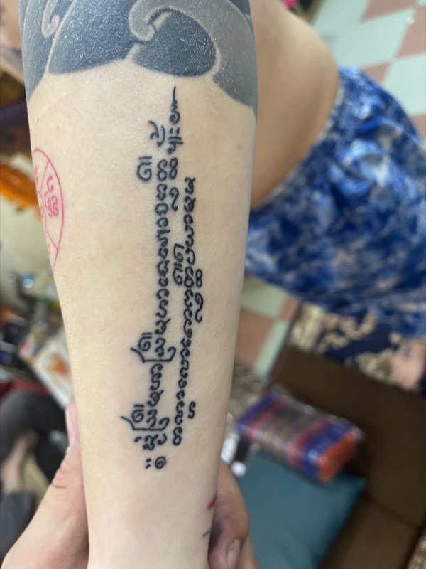 Vertical Khom script on forearm